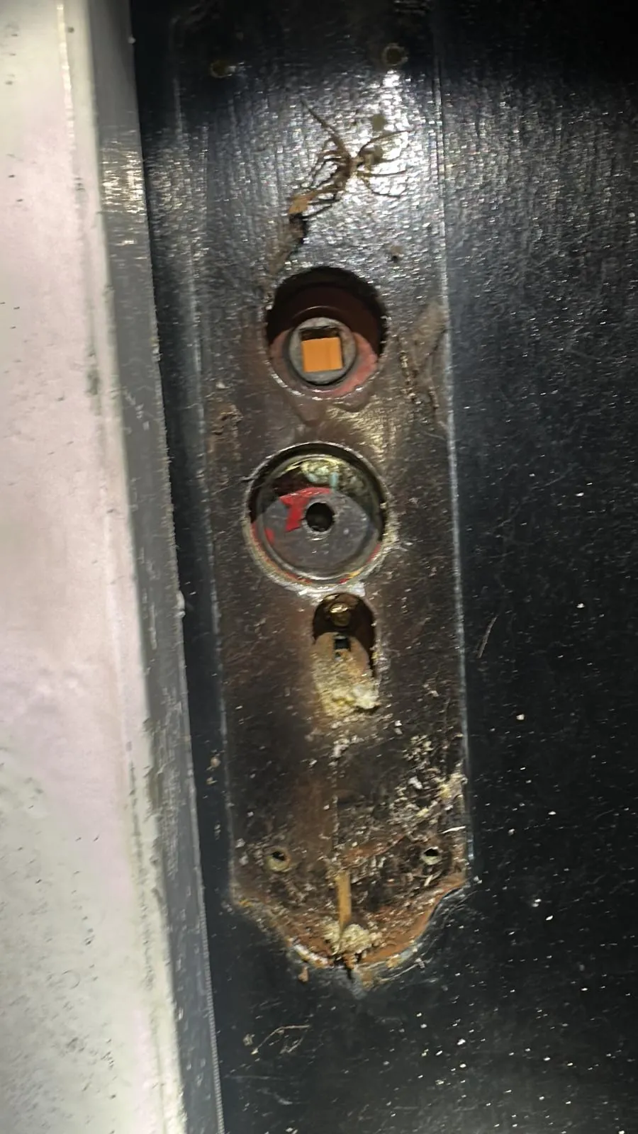 Worn lock fixing points visible on a dark door