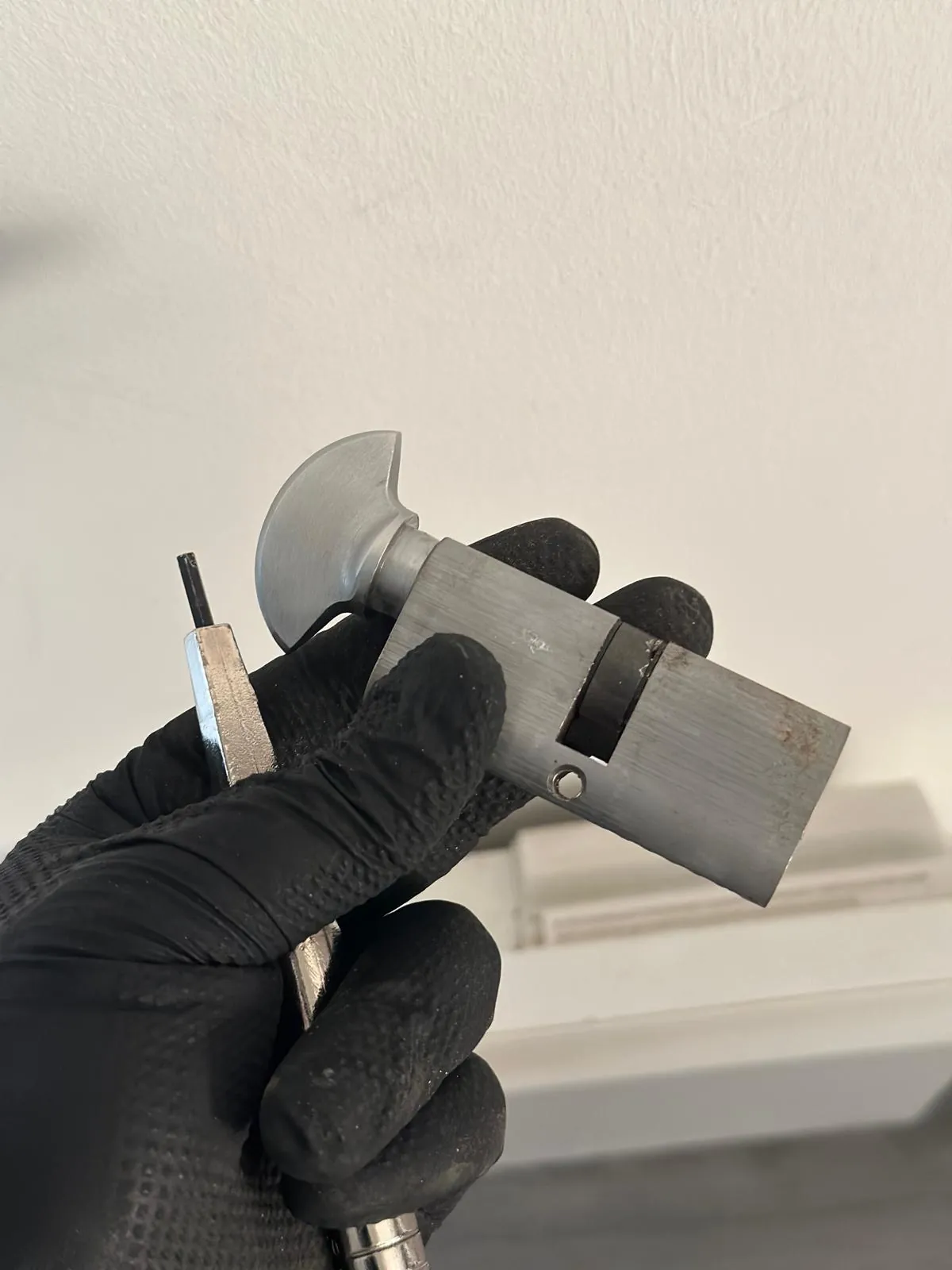 Euro cylinder and key held in a gloved hand